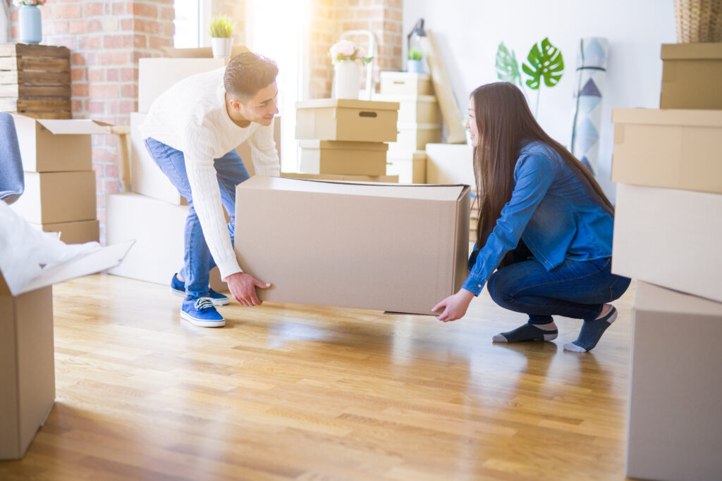 Paar zieht mit Kartons in ein neues Haus nach der Bauendreinigung ein