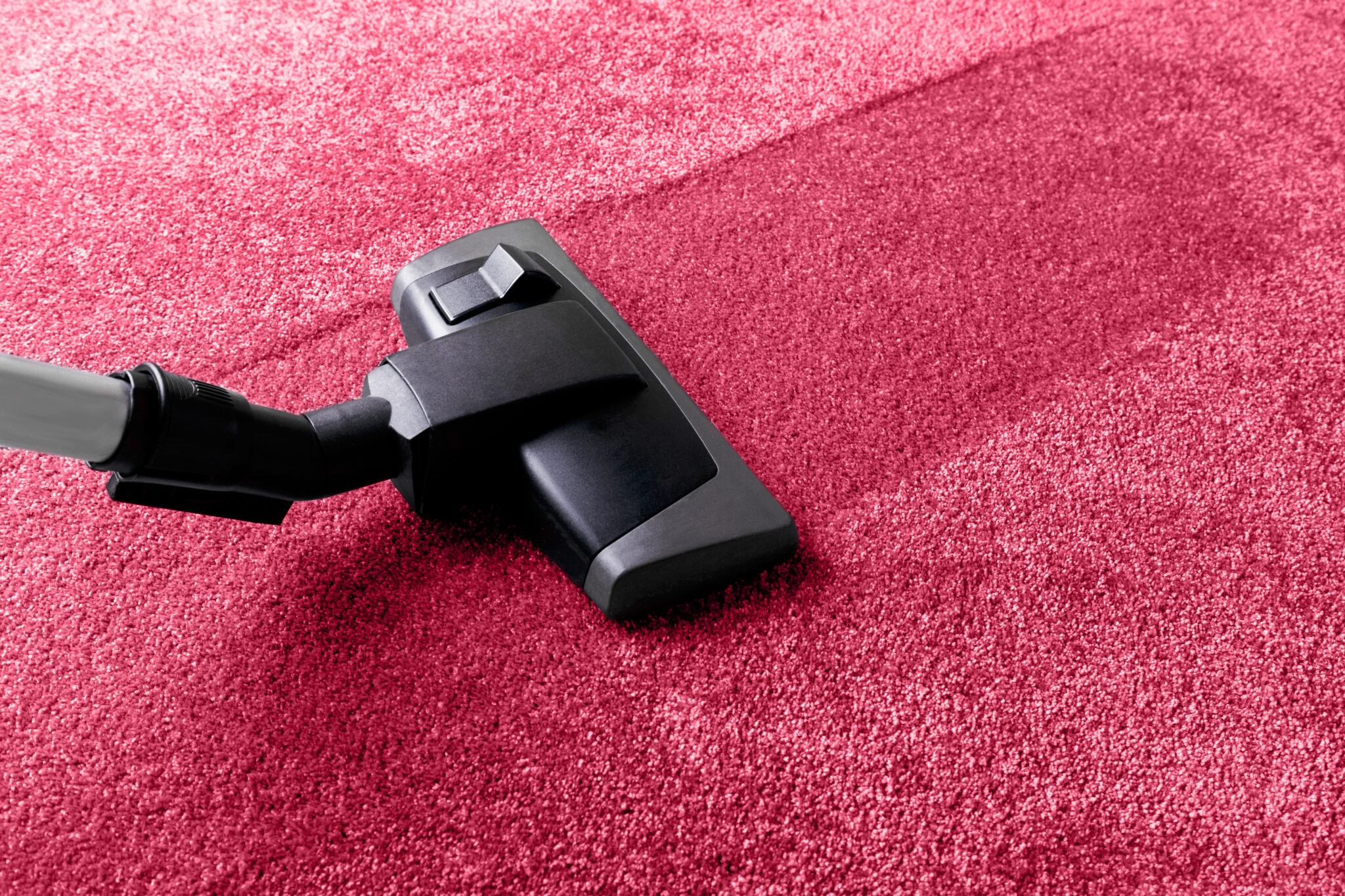 Staubsauger reinigt eleganten roten Teppich
