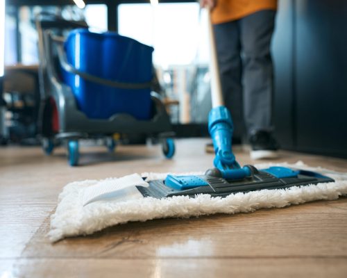 Reinigungsteam wischt Böden mit dem Mopp in einer Wohnung
